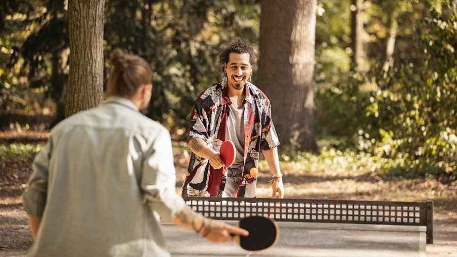 Aktive Männer spielen Ping Pong im Freien